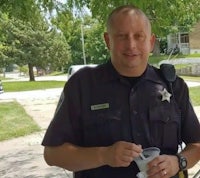 a police officer is holding a cup of ice cream