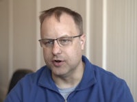 a man in glasses is talking to the camera