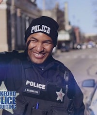 a man in a police uniform is waving to the camera